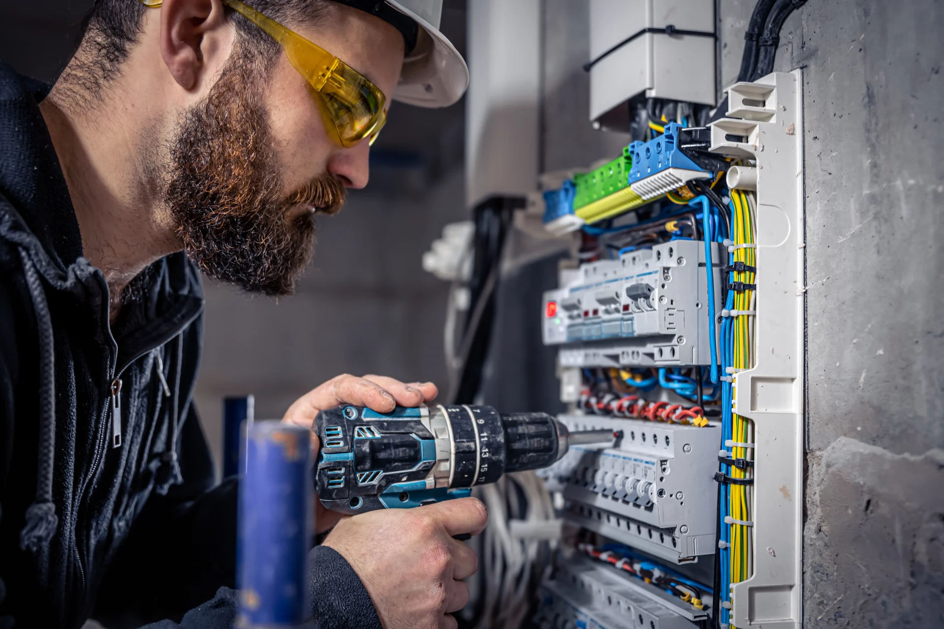 Electrician holding yellow tools on site